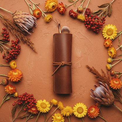 Brown leather brush roll on terracotta with dried wildflowers boho flatlay